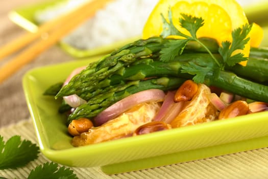 Green asparagus prepared in Thai-style with oranges, onions, cilantro and peanut in an orange-ginger sauce (Selective Focus, Focus on the asparagus head on the top)