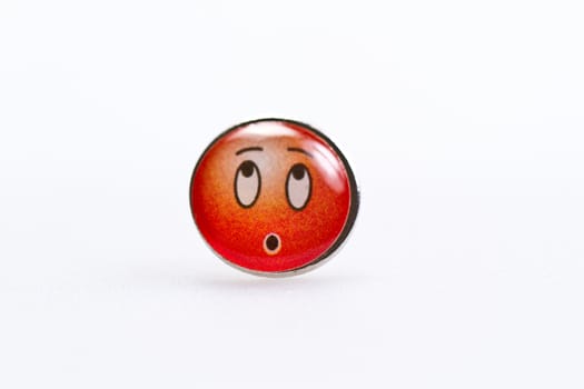 smiley character on metal thumbtack on white surface
