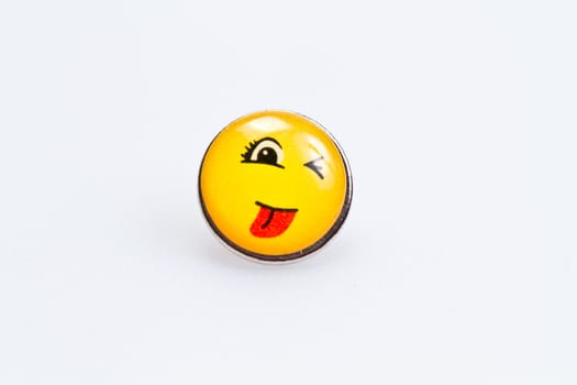 smiley character on metal thumbtack on white surface