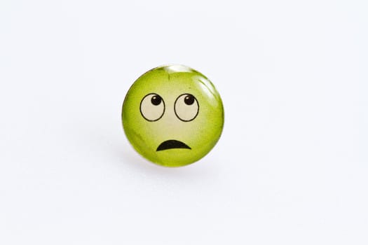 smiley character on metal thumbtack on white surface