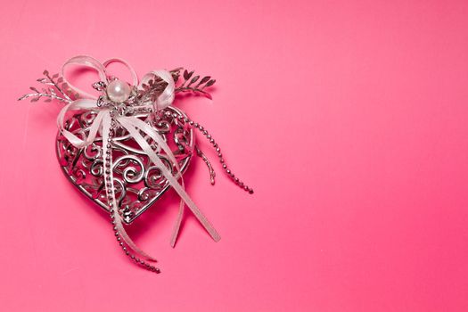 Silver metal heart on pinkish background for valentive use