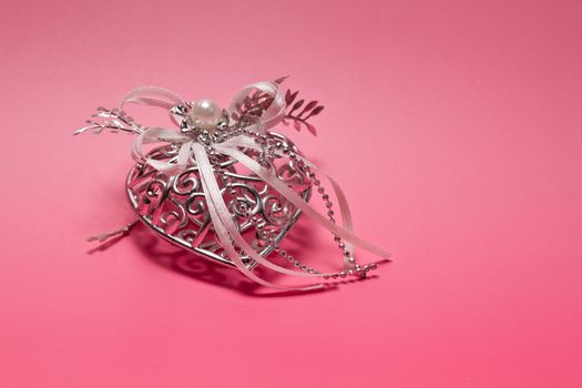 Silver metal heart on pinkish background for valentive use
