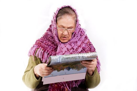 old woman in neckerchief read magazine