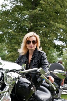 Woman in black leather jacket on a motorcycle