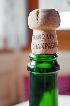 Opened champagne plug over a green bottle