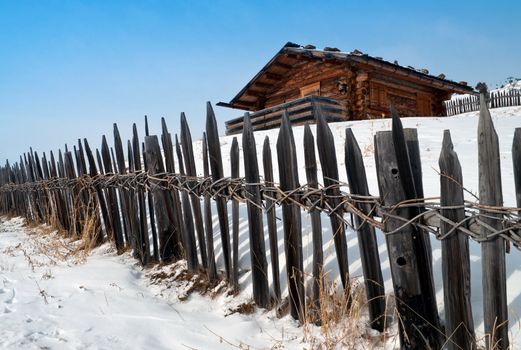 Old winter wood cottage with fence in Dolomiti Alps, Ortisei, italy.