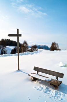 Wooden Winter bench with mark trial in winter snow scape