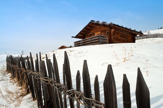 Old winter wood cottage with fence in Dolomiti Alps, Ortisei, italy.