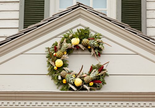 Traditional design of a christmas wreath attached to the front of old house