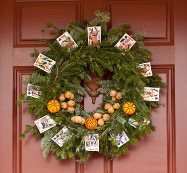 Traditional design of a christmas wreath attached to the front door of old house