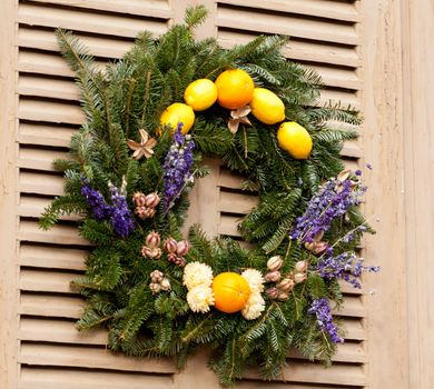 Traditional design of a christmas wreath attached to the front door of old house