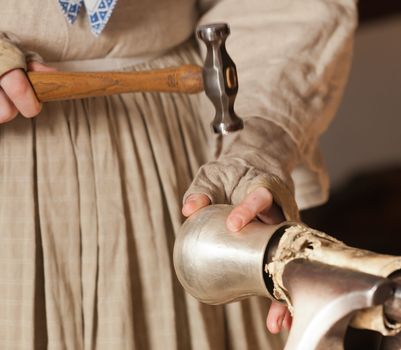 Craftsperson hammering mark into a silver cup to shape it