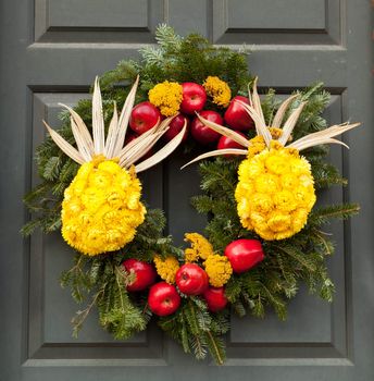 Traditional design of a christmas wreath attached to the front door of old house