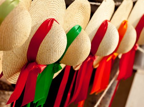 Set of straw woven hats with colorful ribbons in a row