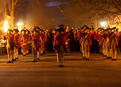 WILLIAMSBURG, VIRGINIA - DECEMBER 29: Marching soldiers at night on December 29, 2011. Colonial Williamsburg's 301 acres includes many restored buildings and houses and hosts re-enactments.