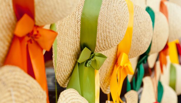 Set of straw woven hats with colorful ribbons in a row