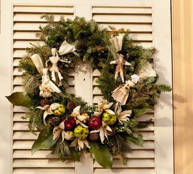 Traditional design of a christmas wreath attached to the front door of old house