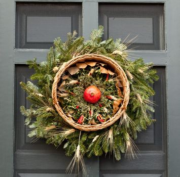Traditional design of a christmas wreath attached to the front door of old house