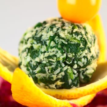 Spinach coconut ball garnished with physalis served on orange peel and grated beetroot (Selective Focus, Focus on the front of the coconut ball)