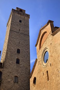 Collegiate Church S. Maria Assunta Facade Stained Glass Tower Grosse Rognosa San Gimignano Tuscany Italy San Gimignano is a medieval town and the Towers were build for defense.