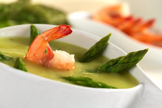 Cream of green asparagus with shrimp (Selective Focus, Focus on the front of the shrimp)