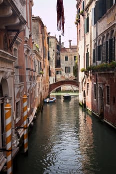 Small Canal Bridge Yellow Poles Buildings Boats Reflections Venice Italy