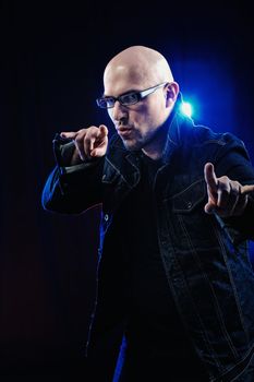 Man with glasses and in denim jacket. Studio-style portrait