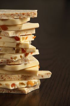 Slabs of assorted delightful white chocolate goodness stacked on top of each other on a wood table.