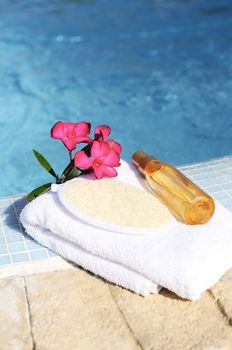 massage oil, shellfish and white towel beside a pool