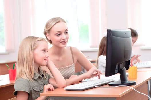 teacher explains the task schoolgirl at the computer, the new technologies in education