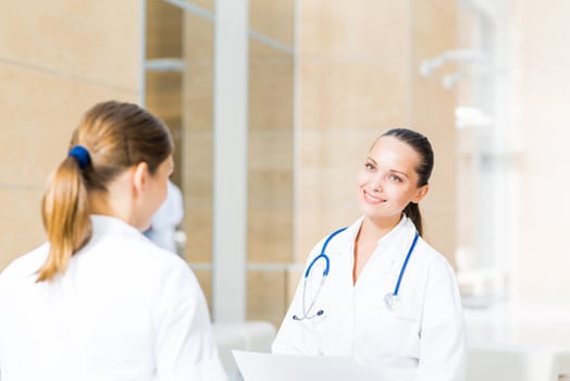 two doctors talking in the lobby of the hospital, sitting on the couch