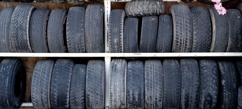 A double rack of old and worn rubber auto tires