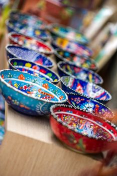 Small beautiful arabic colorful pottery bowls arranged in a row at the street market of Antalya, Turkey