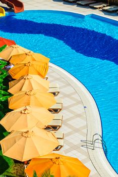 Outdoor pool with sunbeds and umbrellas in luxury resort