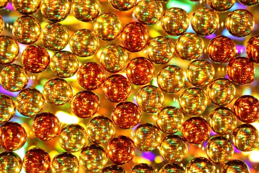 Background of glowing gold and orange balls with festive lights behind, christmas, holiday or party theme.