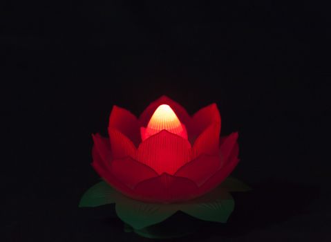 Lighting lotus lamp in dark is a symbol of wisdom overcoming ignorance.