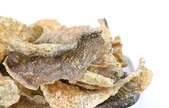 Crispy fried fish skin with spices on white background