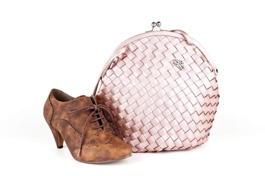 Pink bag with a shoe on white background.