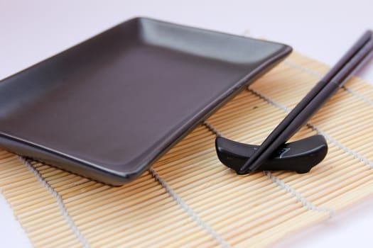 Sushi sticks and black plate