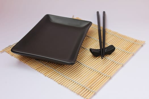 Sushi sticks and black plate
