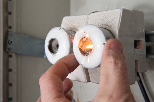 Person mounting new fuse on short circuited line