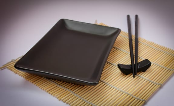 Sushi sticks and black plate