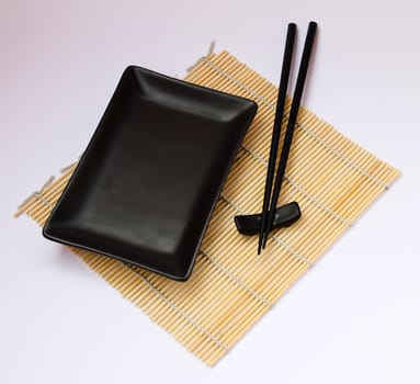 Sushi sticks and black plate