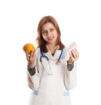 woman doctor in one hand holding an orange in the other tablets on a white background isolated