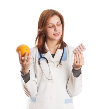 doctor in medical uniform makes a choice between natural vitamins and pills on a white background isolated