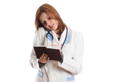 female doctor taking notes in a notebook and talking on the phone isolated on white background
