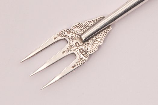 Hallmarked sterling silver pickle fork on a white background.