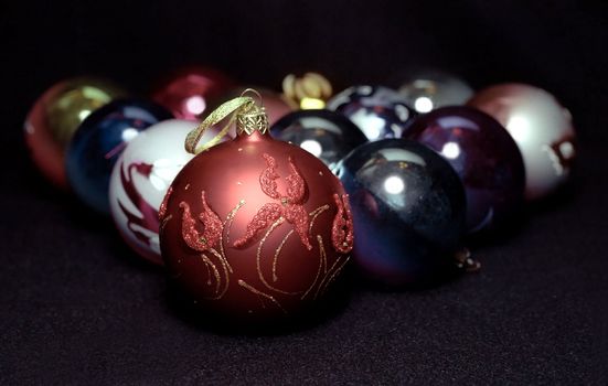 Red glass sphere with Christmas decoration on black background