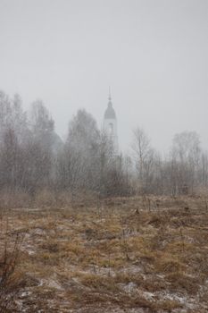 View of church through heavy hailing, early spring, Russia