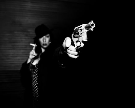 Woman spy aiming handgun smoking a cigarette.